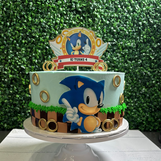 Sonic the Hedgehog birthday cake on a stand with a green leafy background